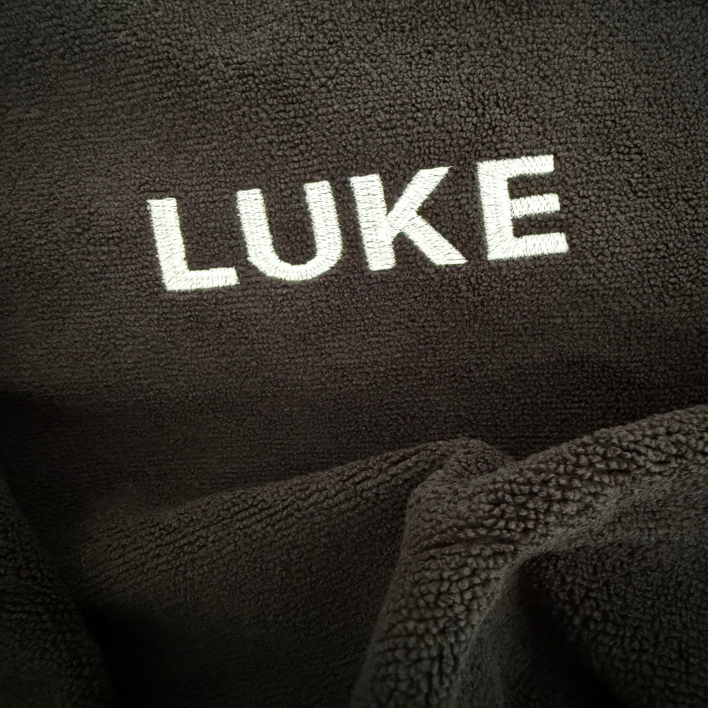 Black car seat towel with LUKE embroidered into headrest