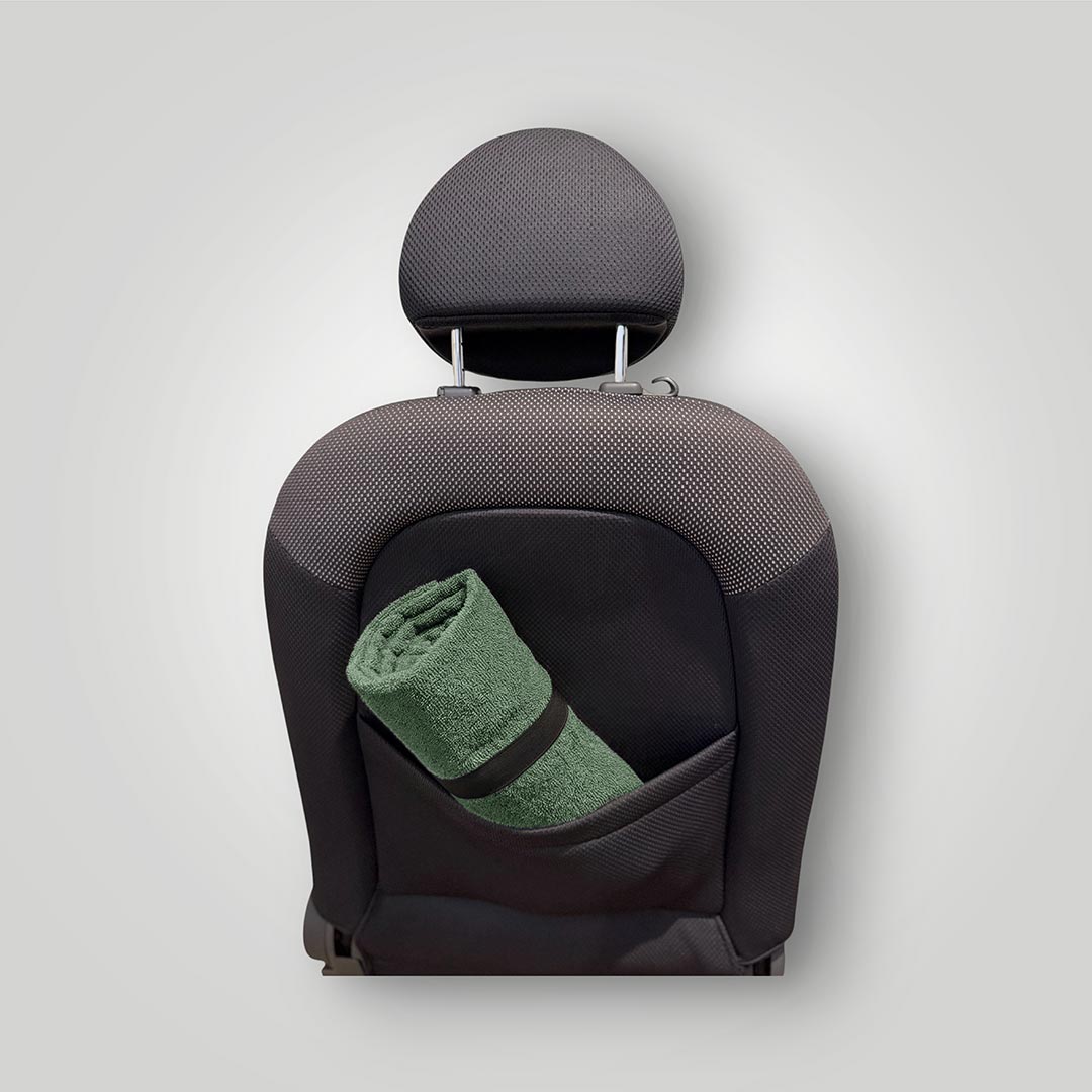 Moss green waterproof car seat towel rolled and stored in the back of a seat
