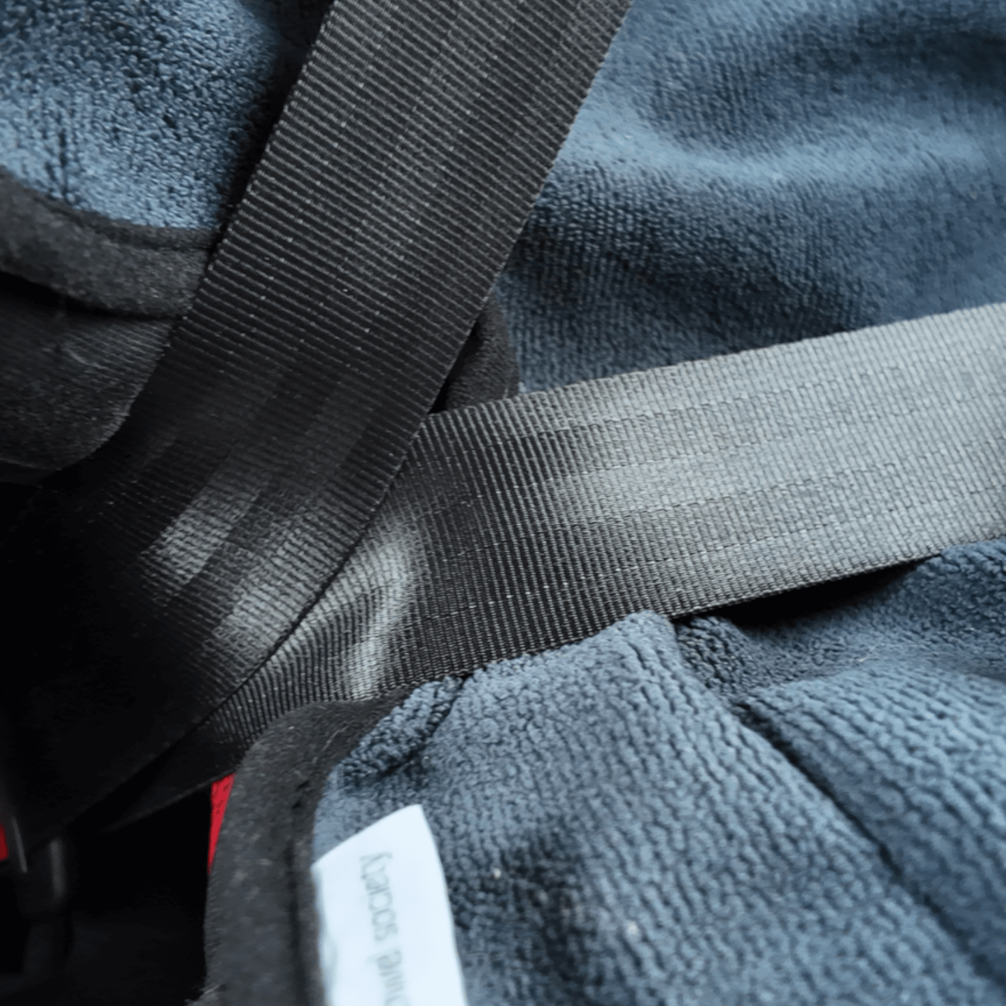 Close-up of waterproof child seat towel in charcoal grey with safety straps for added protection.