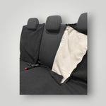 Black rear car seat cover with beige interior on a grey background