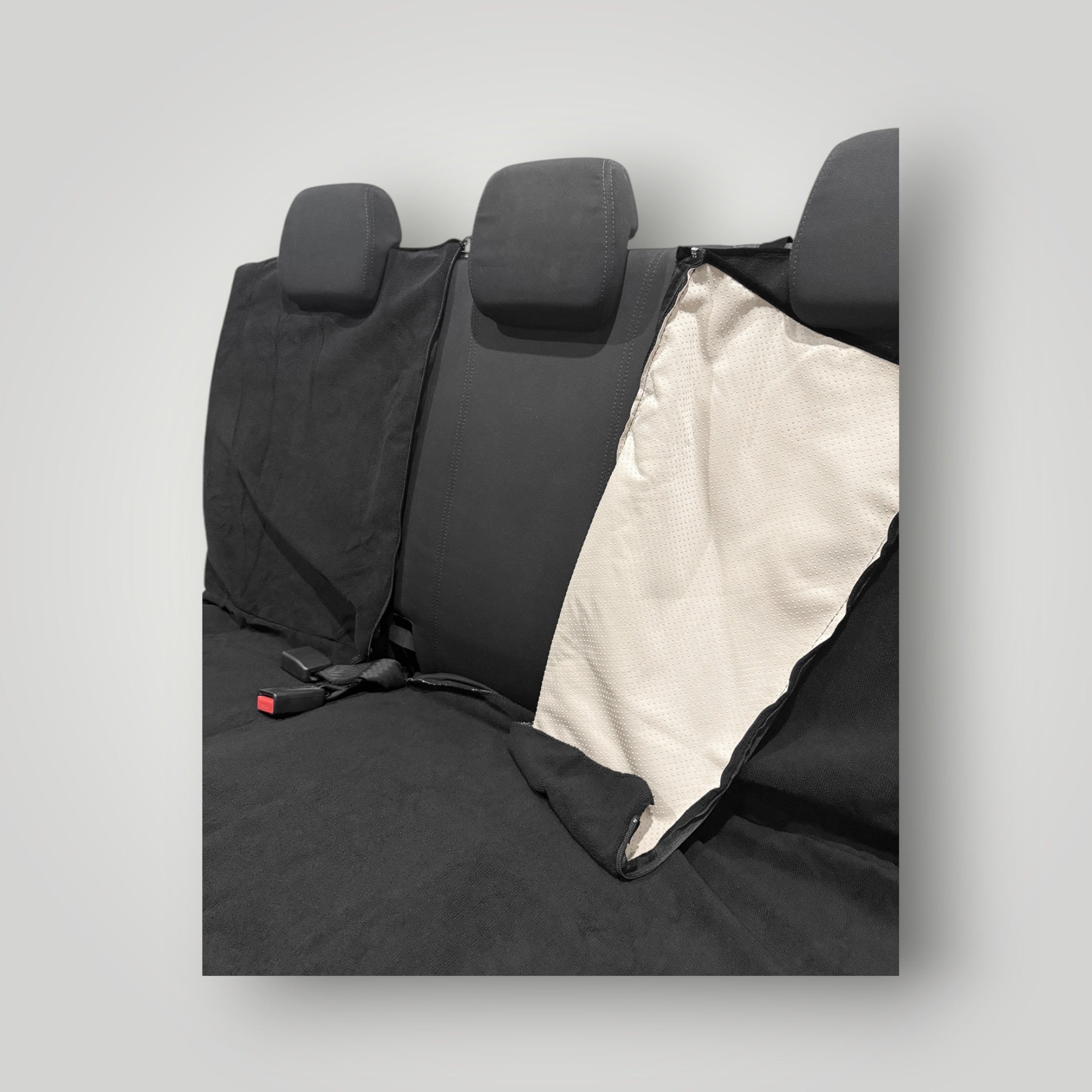 Black rear car seat cover with beige interior on a grey background
